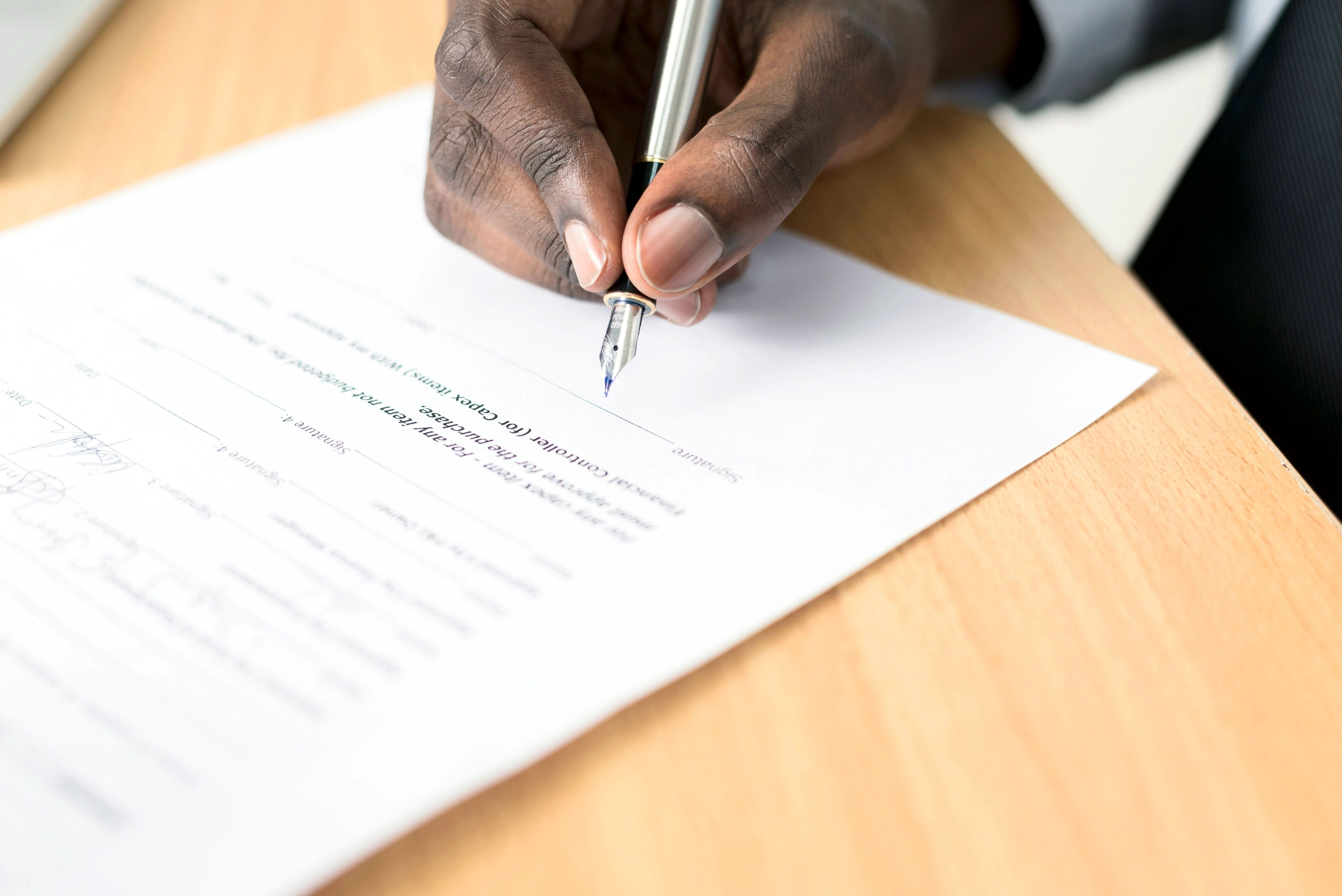 Hand signing a contract with a fountain pen